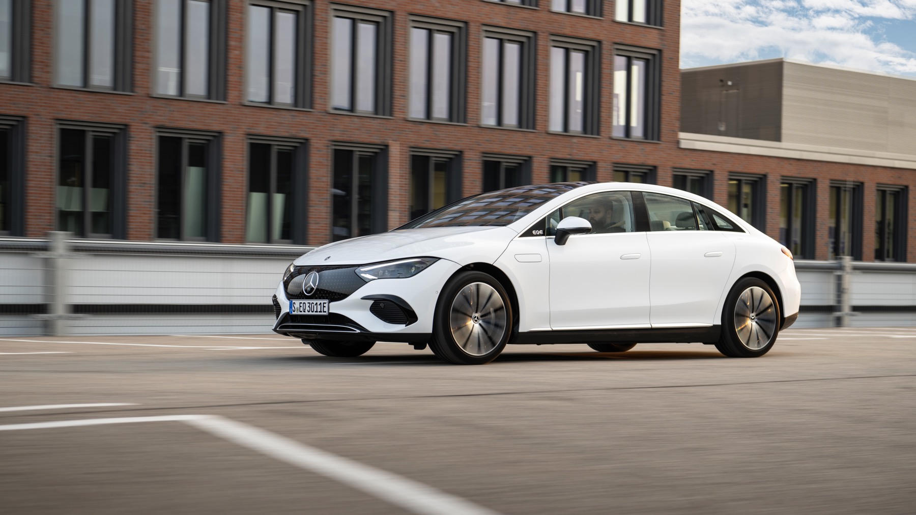 Mercedes EQE front three quarter action, white car, German registration